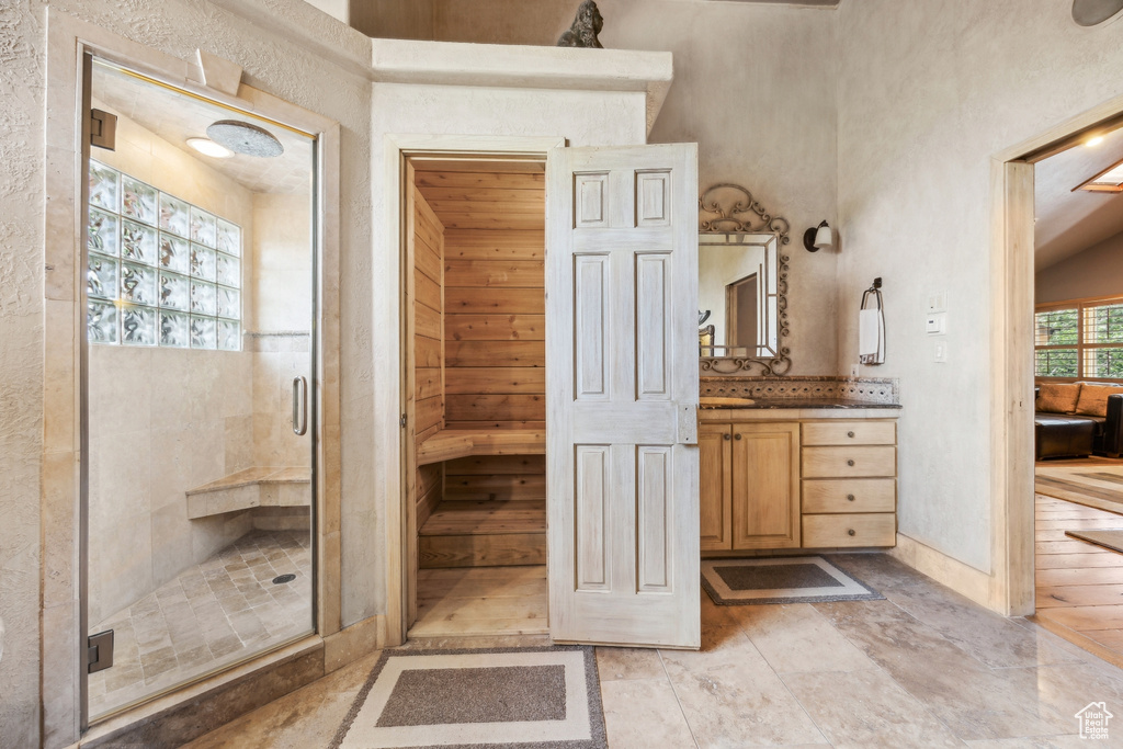 Bathroom featuring walk in shower, tile floors, and large vanity