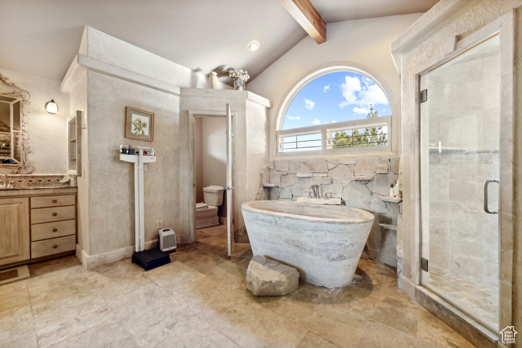 Full bathroom with vanity with extensive cabinet space, toilet, shower with separate bathtub, vaulted ceiling with beams, and tile flooring