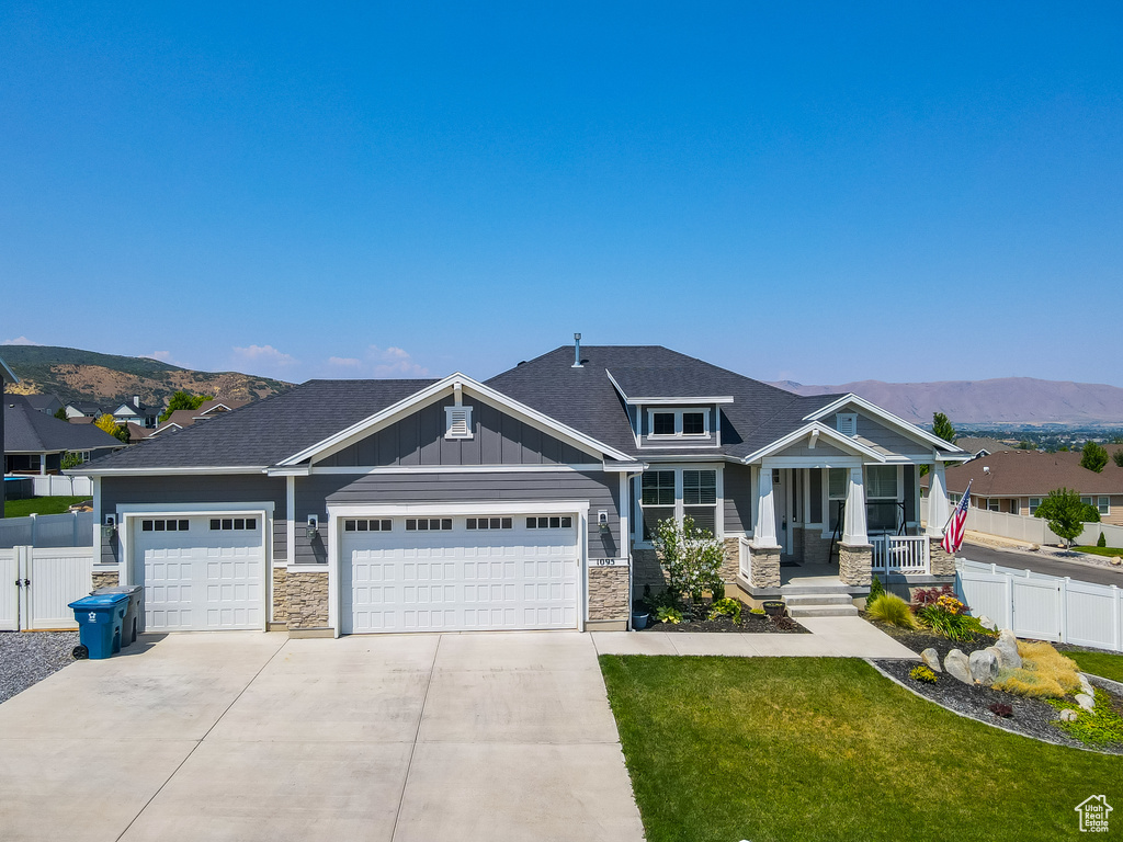 Craftsman house with a garage, a front lawn, and a mountain view