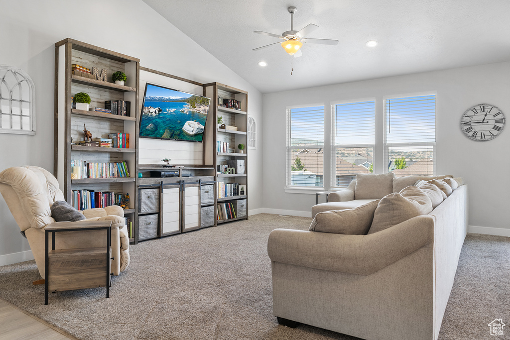 Carpeted living room featuring ceiling fan and lofted ceiling