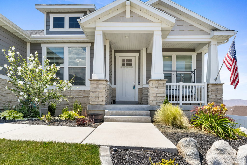 Doorway to property featuring covered porch