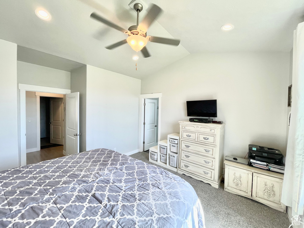 Carpeted bedroom with ceiling fan and lofted ceiling