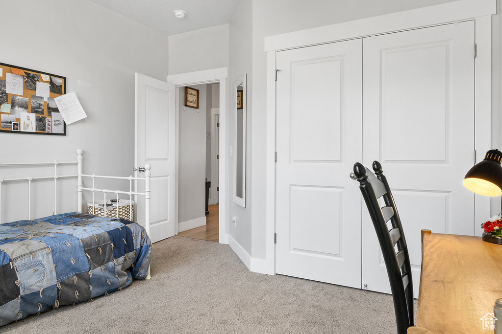 Bedroom featuring light carpet and a closet