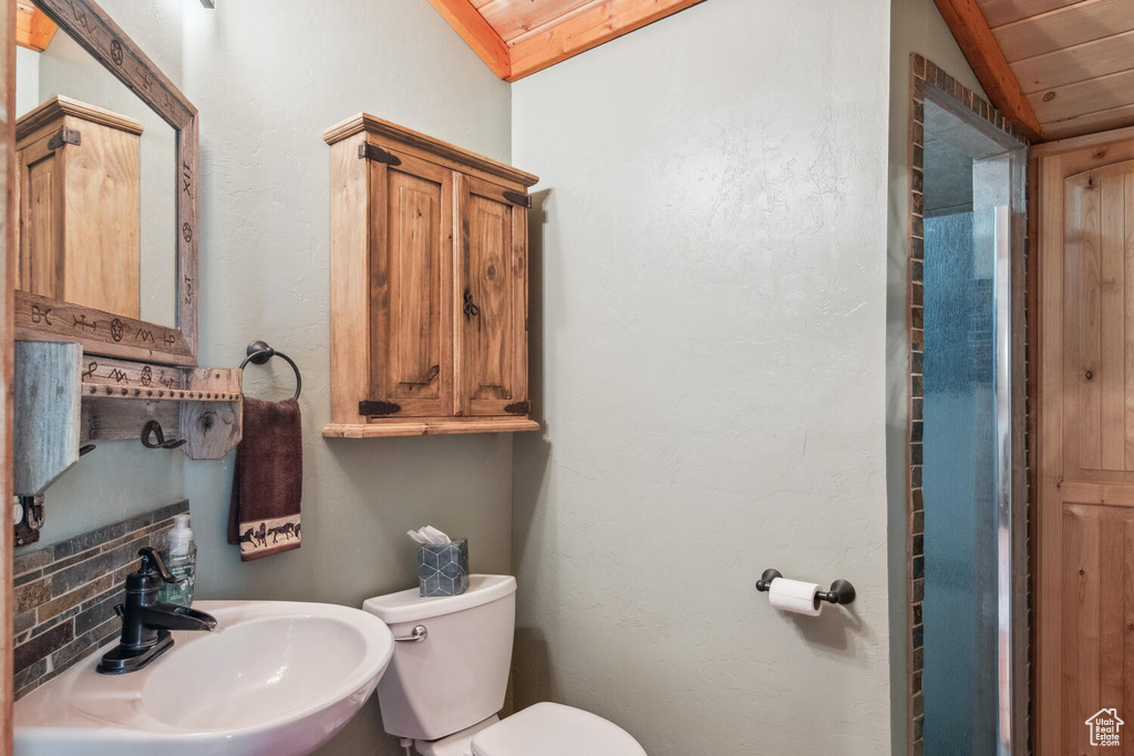 Bathroom with wooden ceiling, sink, lofted ceiling, and toilet