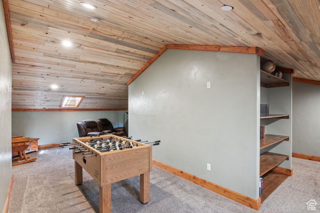 Recreation room featuring vaulted ceiling, carpet flooring, and wood ceiling