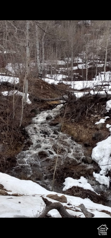 View of snow covered land featuring a water view