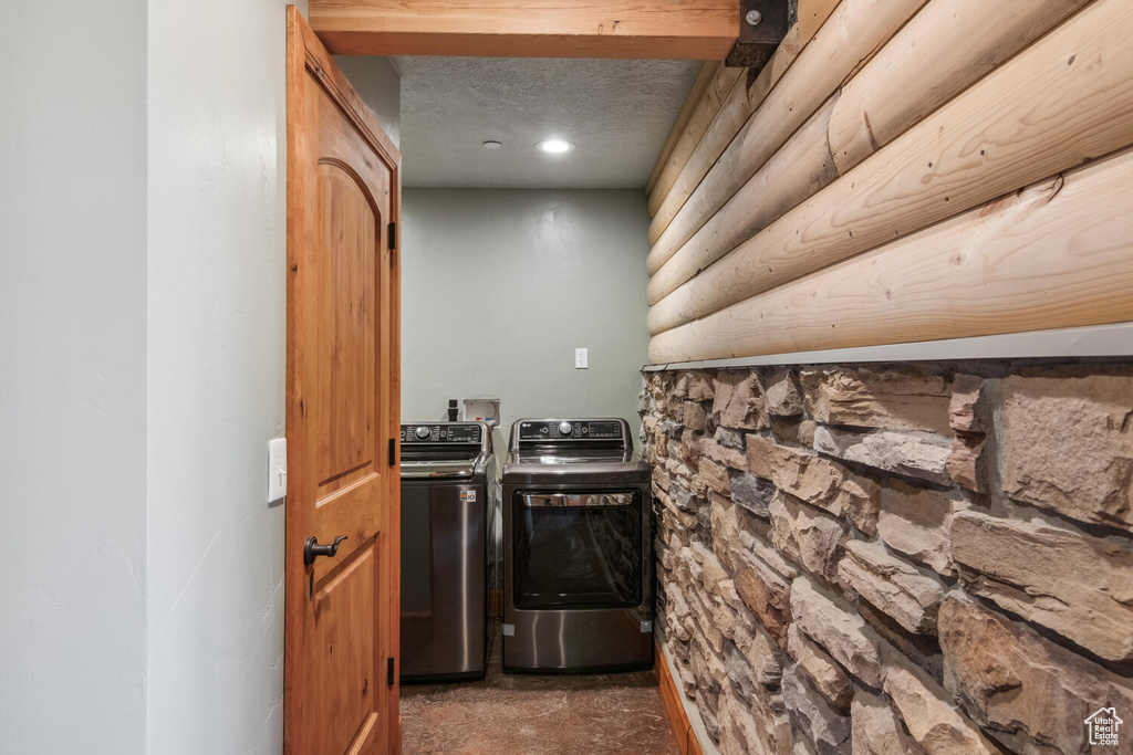 Laundry room featuring washer and dryer, a textured ceiling, and hookup for a washing machine