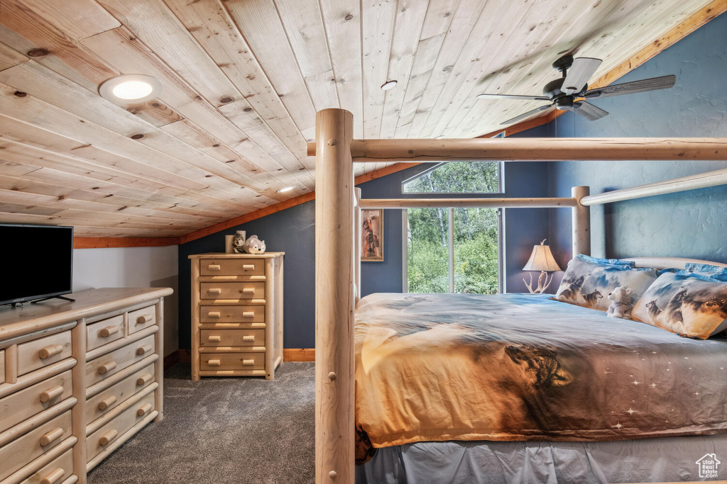 Bedroom featuring wooden ceiling, dark colored carpet, ceiling fan, and vaulted ceiling