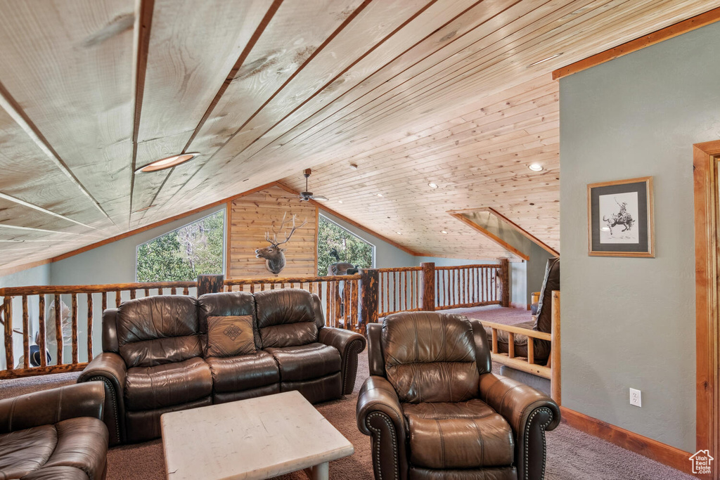 Carpeted living room with wood walls, ceiling fan, wood ceiling, and lofted ceiling