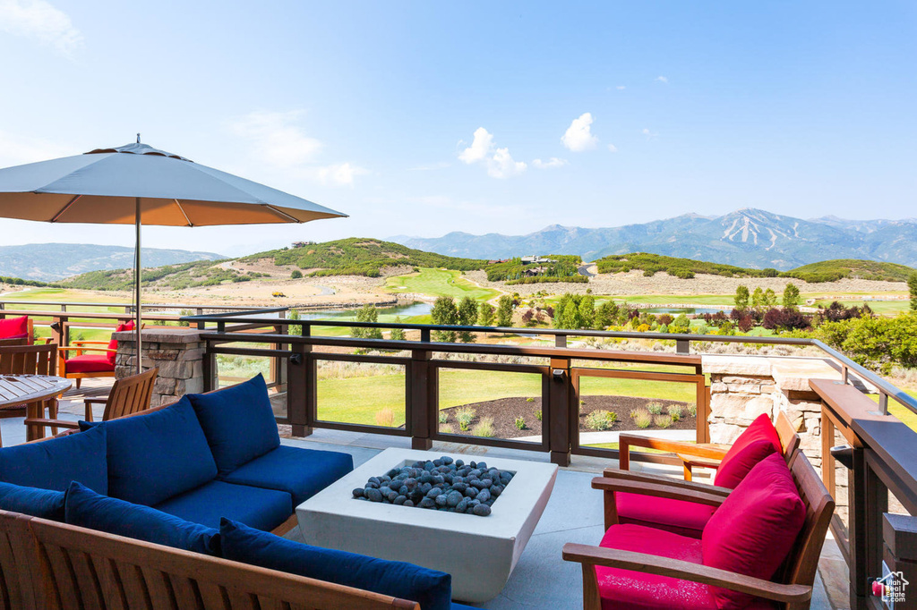 Deck featuring a mountain view and an outdoor living space with a fire pit