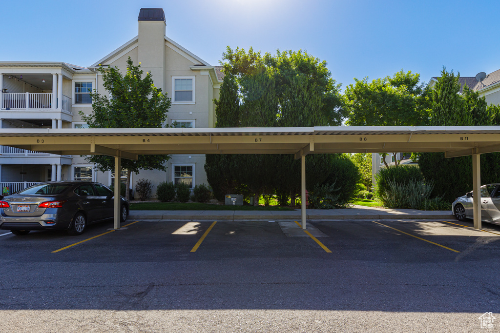 View of parking / parking lot featuring a carport