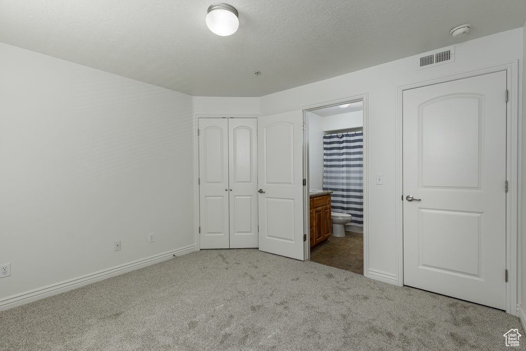 Unfurnished bedroom featuring carpet floors and connected bathroom