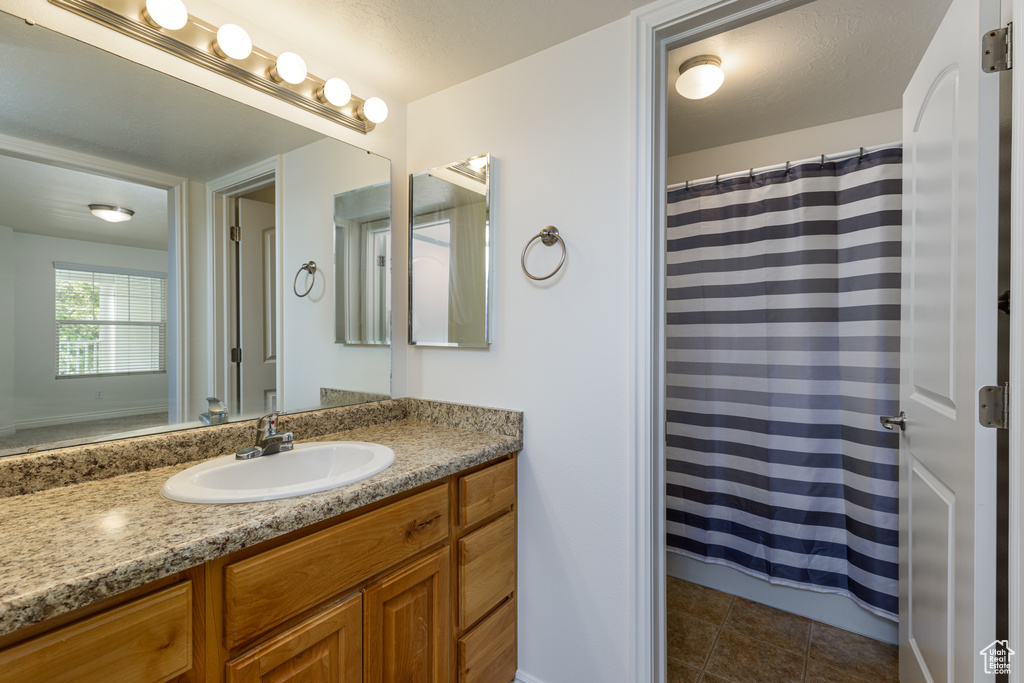 Bathroom featuring tile floors and vanity with extensive cabinet space