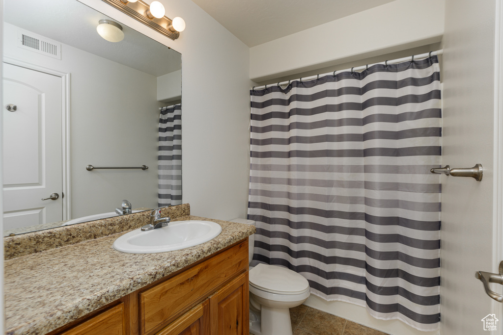 Bathroom with tile flooring, large vanity, and toilet