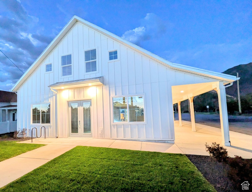 Back of property with a patio area, a lawn, and french doors