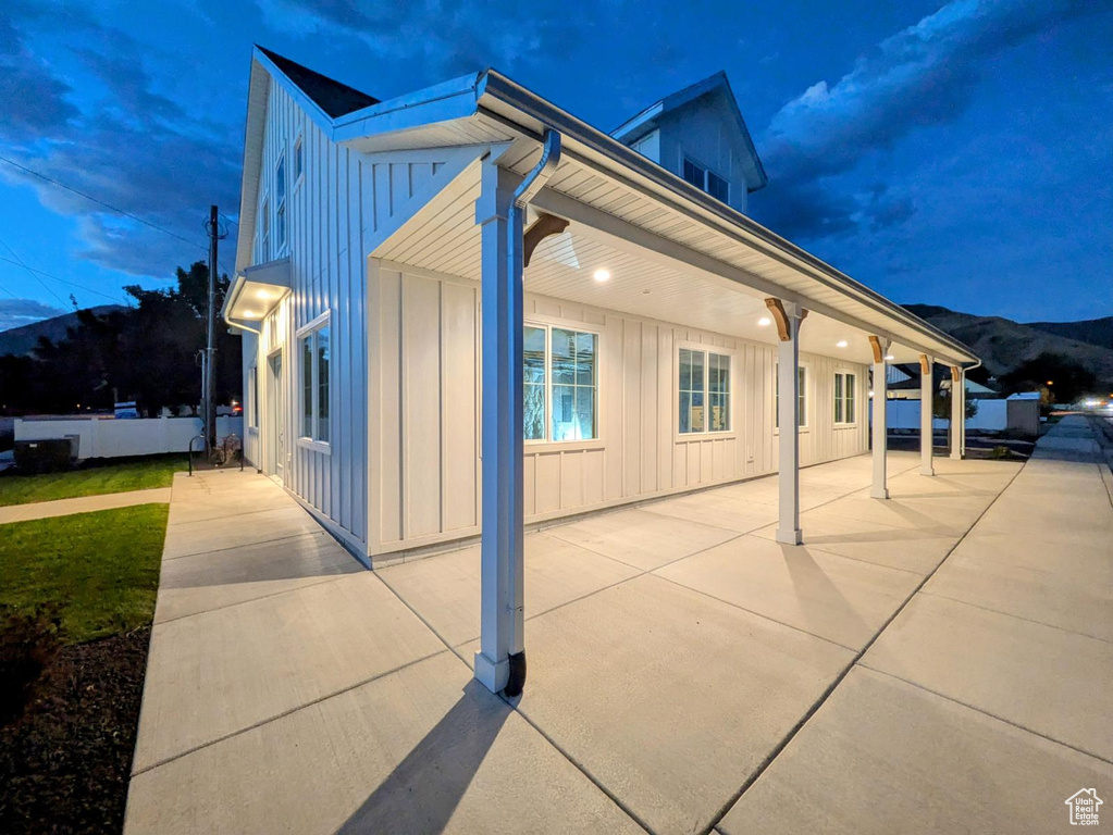 Property exterior at twilight with a mountain view and a patio area