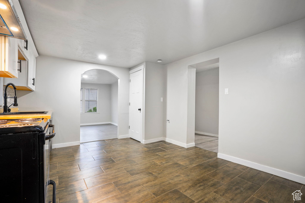 Interior space featuring dark wood-type flooring, sink, and electric range