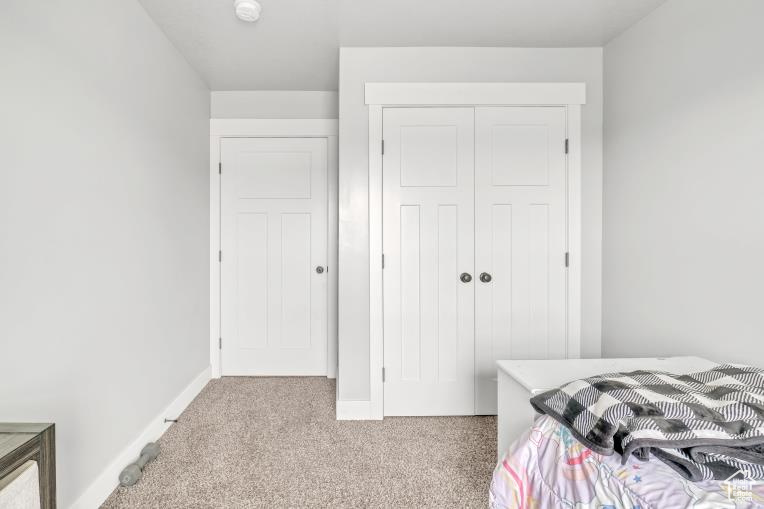 Carpeted bedroom featuring a closet