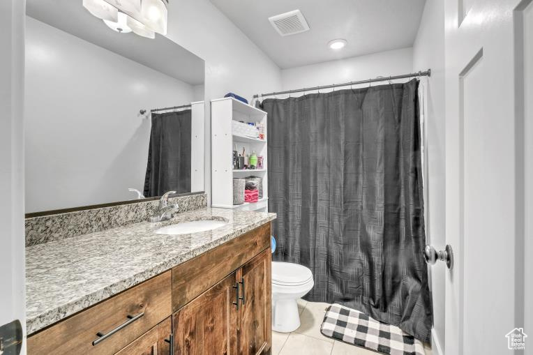 Bathroom with tile floors, toilet, and large vanity