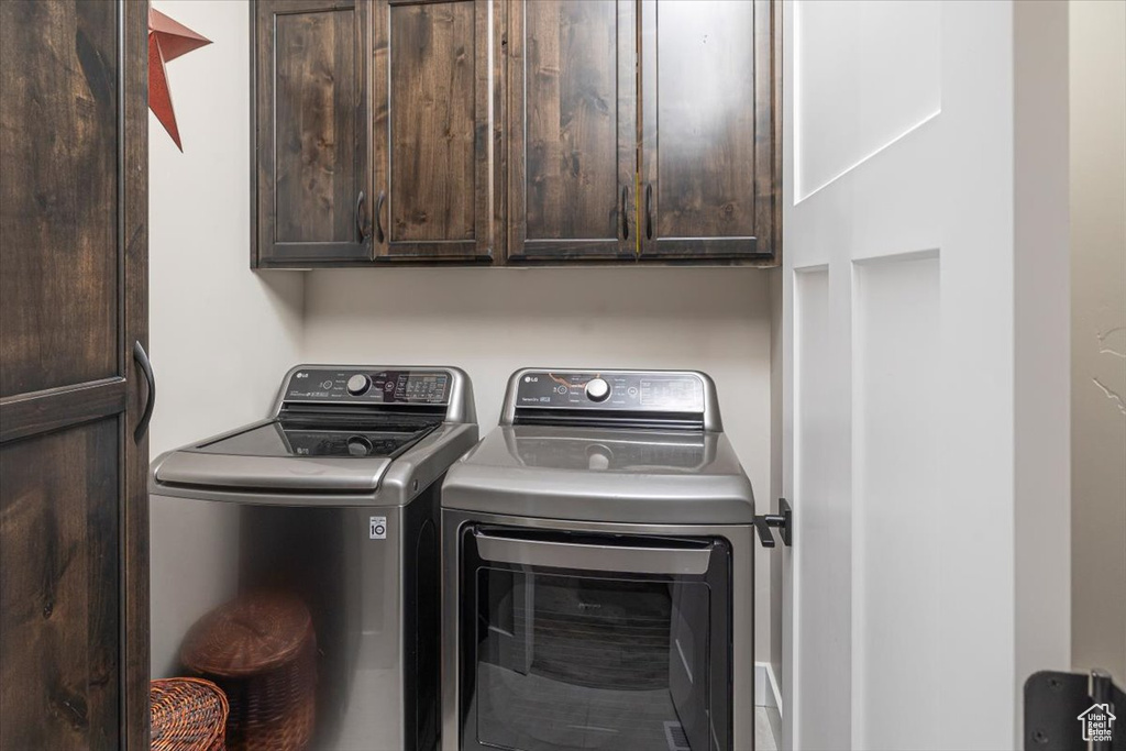 Washroom with washing machine and clothes dryer and cabinets