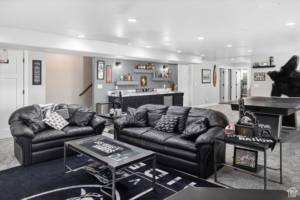 Carpeted living room featuring bar area