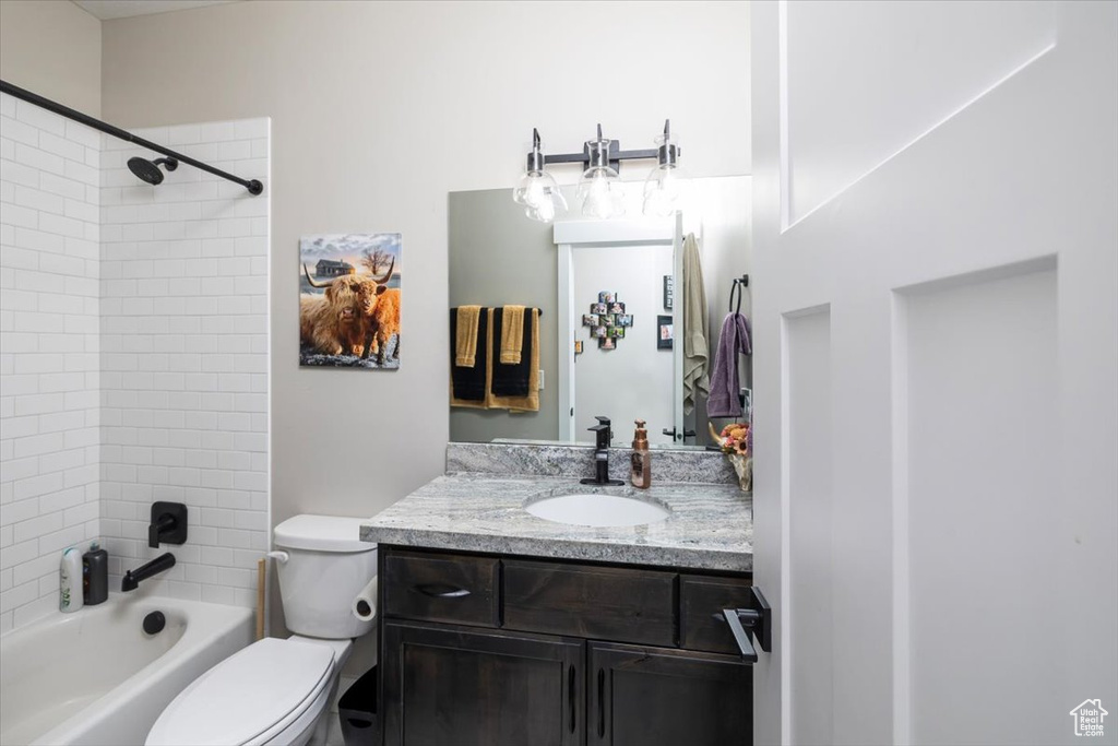 Full bathroom featuring vanity, toilet, and tiled shower / bath combo