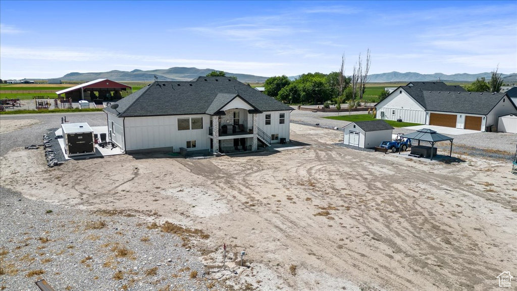 Back of property with a garage, a mountain view, and an outdoor structure