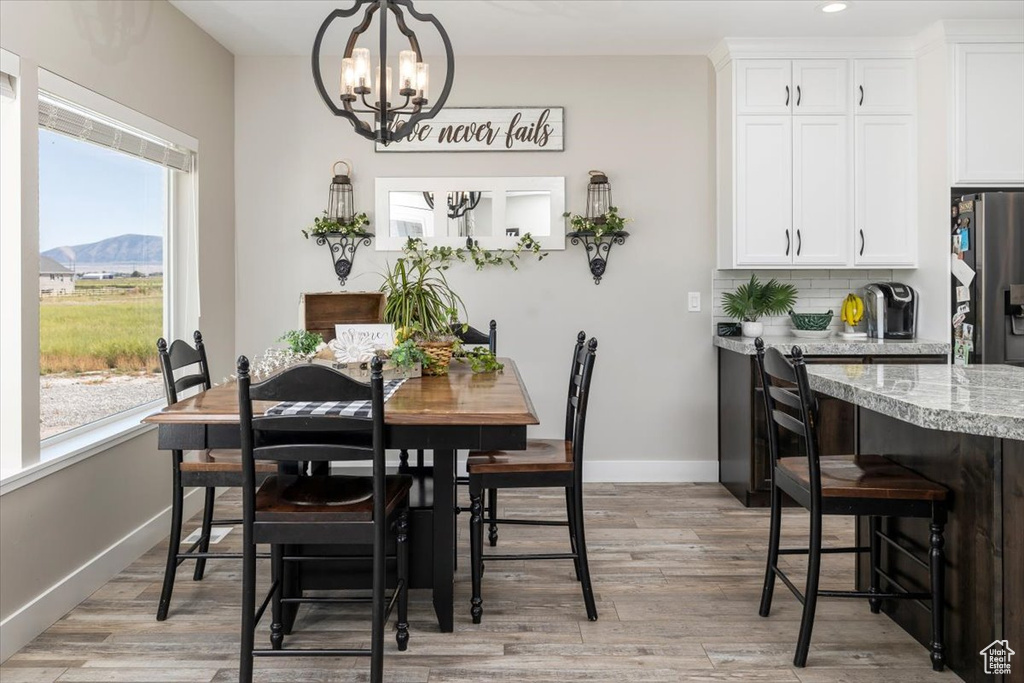 Dining space featuring an inviting chandelier, plenty of natural light, a mountain view, and light hardwood / wood-style floors