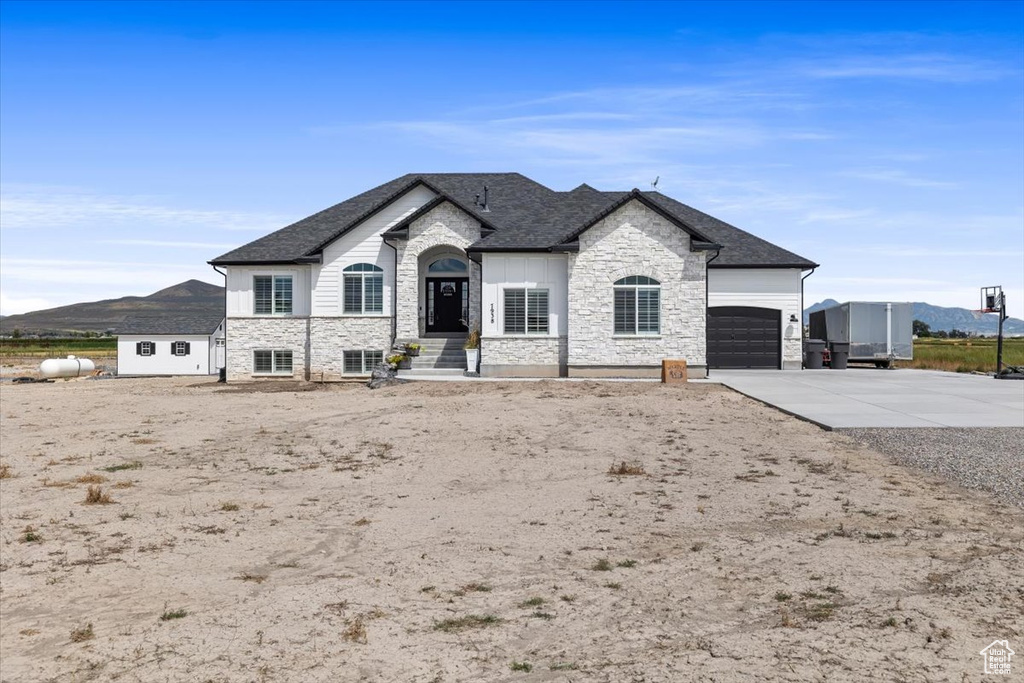 French provincial home featuring a garage and a mountain view