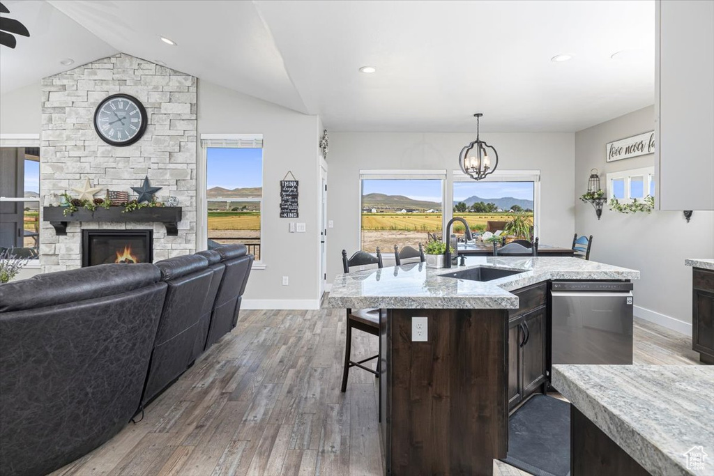 Kitchen with dark brown cabinetry, sink, dark hardwood / wood-style flooring, and decorative light fixtures