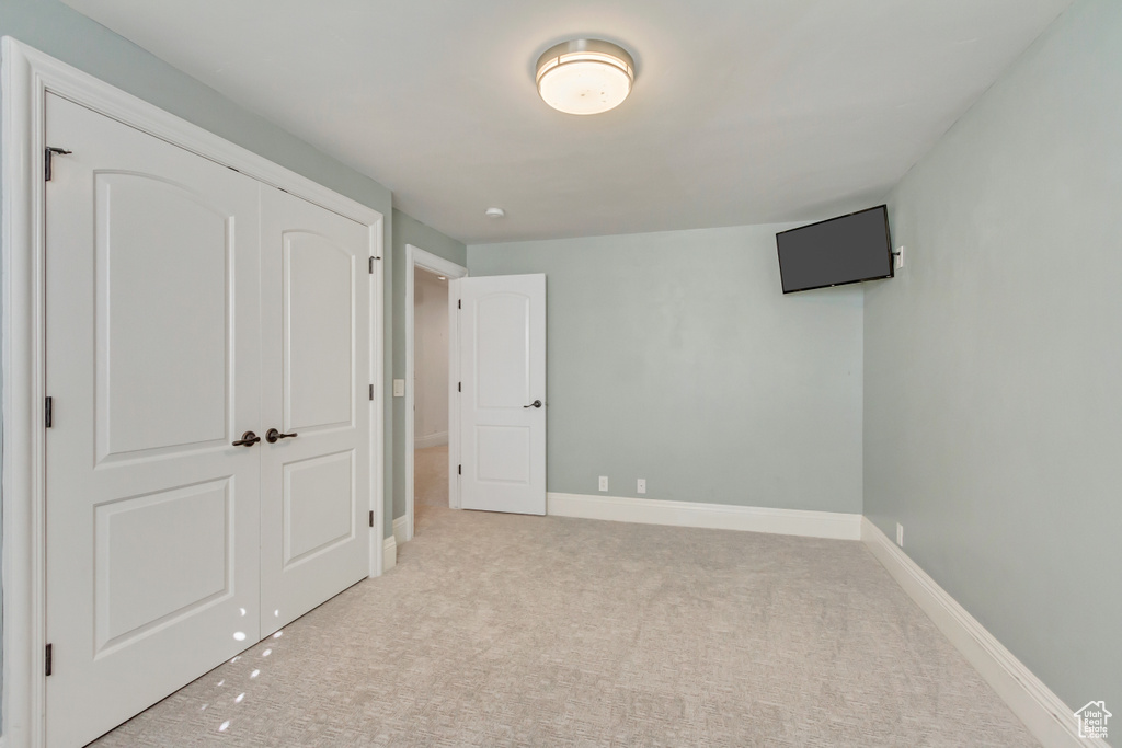 Unfurnished bedroom featuring a closet and light carpet