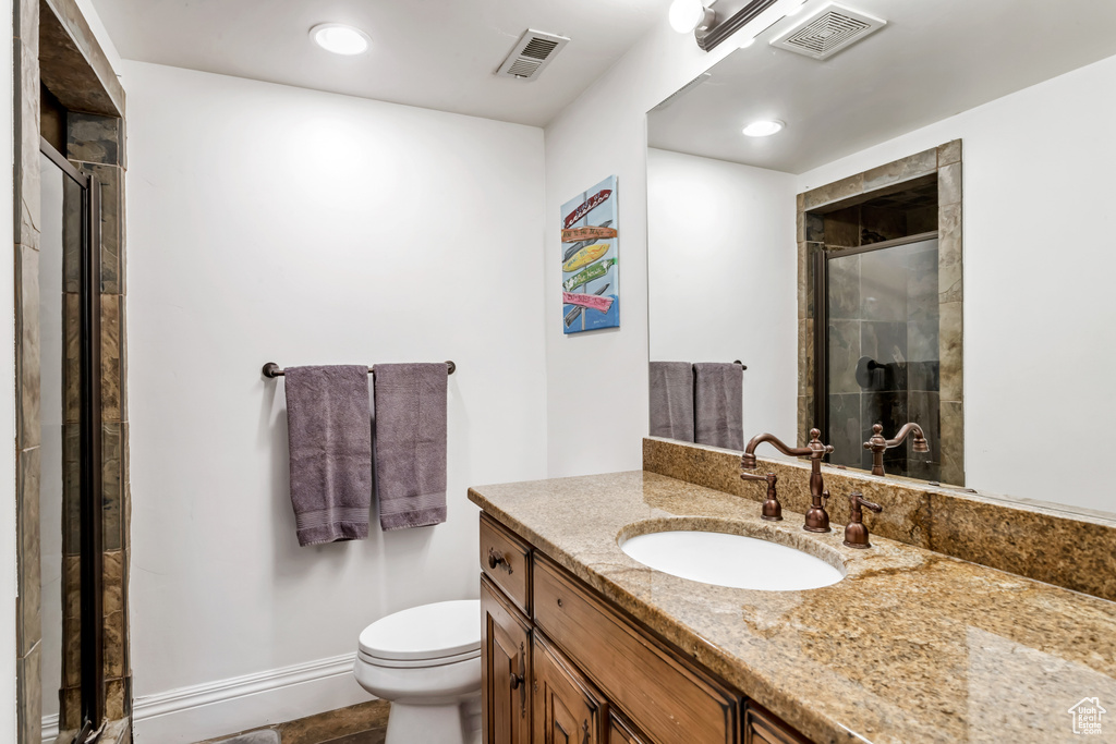 Bathroom with vanity, toilet, and a shower with door