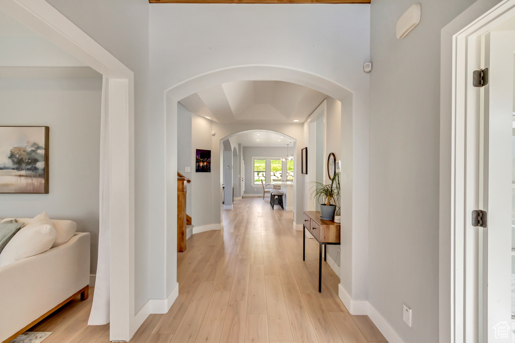 Hall with a notable chandelier and light wood-type flooring