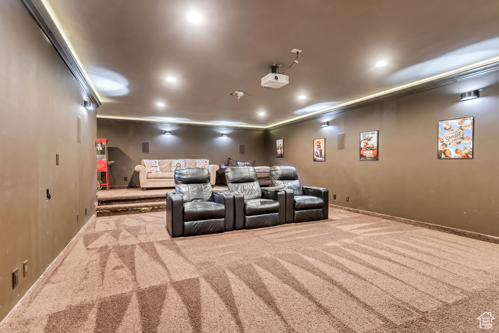 Home theater featuring ornamental molding and light colored carpet