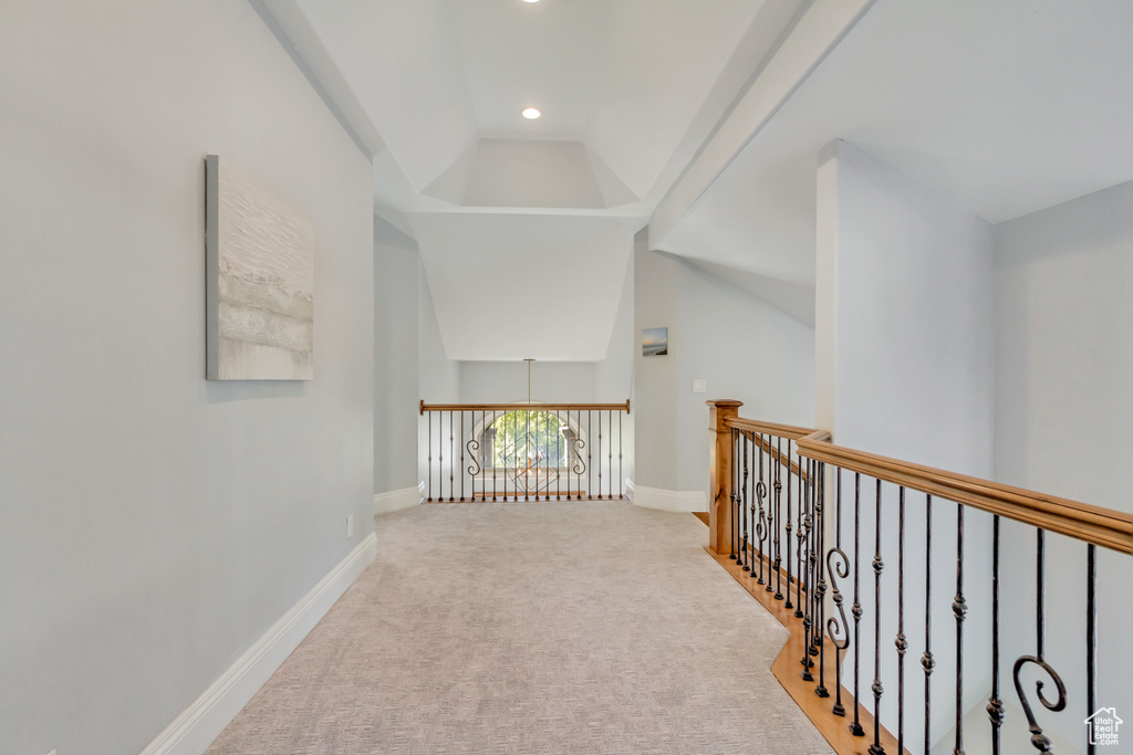 Hall featuring light carpet and vaulted ceiling