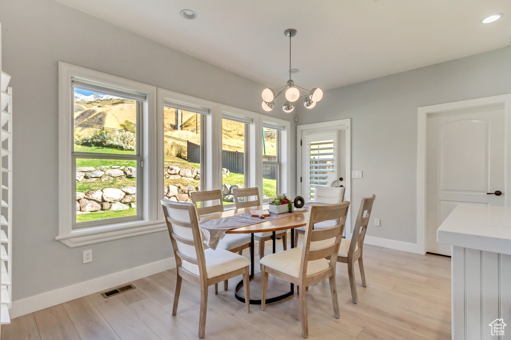 Dining area featuring an inviting chandelier and light wood-type flooring