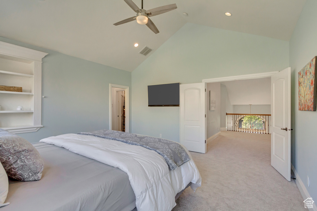 Carpeted bedroom featuring ceiling fan and high vaulted ceiling