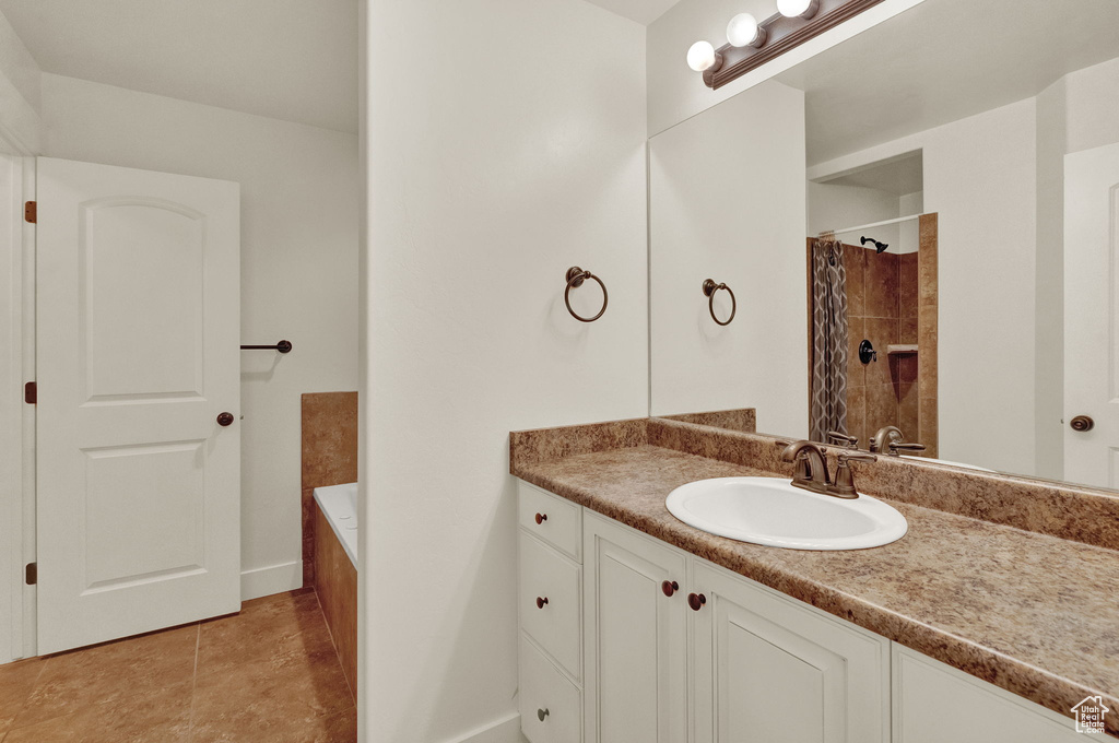 Bathroom featuring a bathtub, tile flooring, and vanity with extensive cabinet space