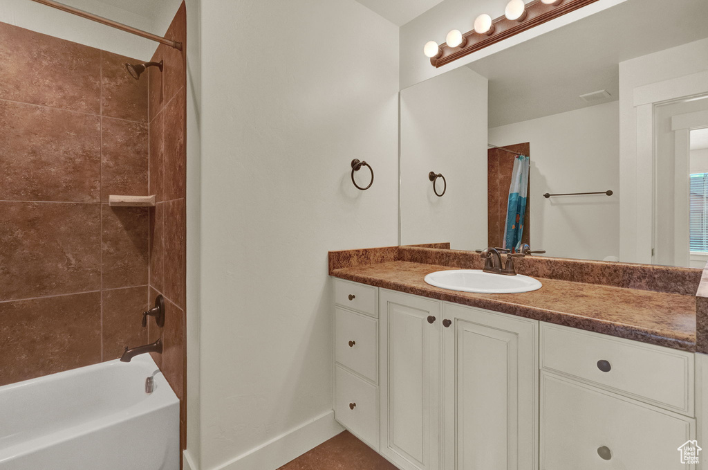 Bathroom featuring shower / bath combination with curtain and vanity