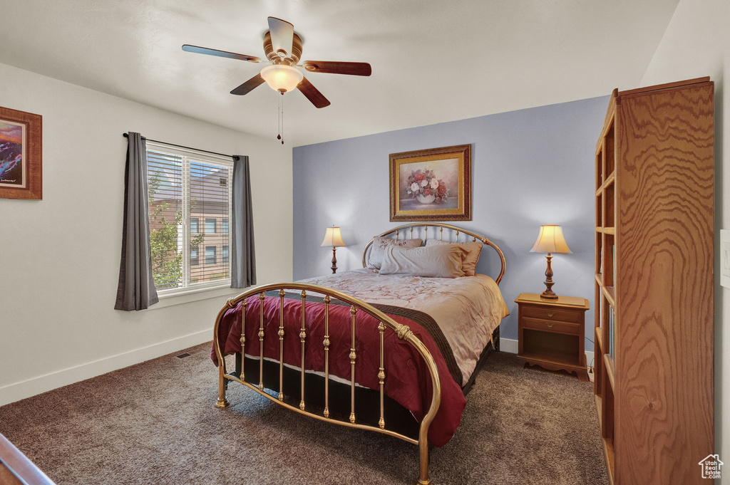 Bedroom with ceiling fan and dark carpet