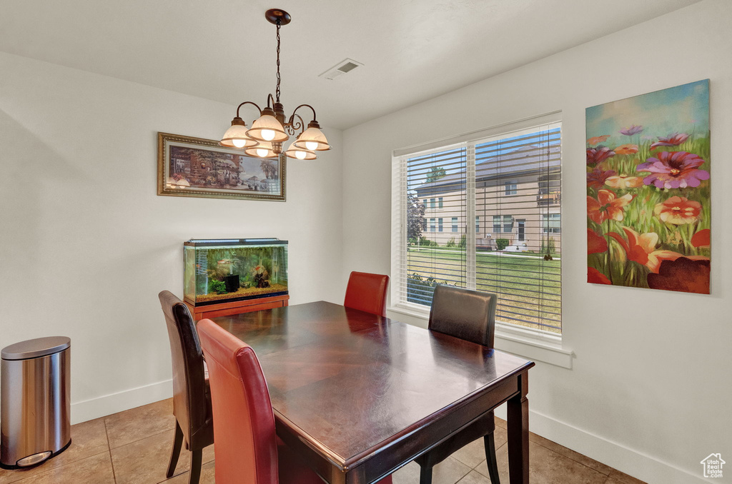 Dining room with a chandelier and tile flooring