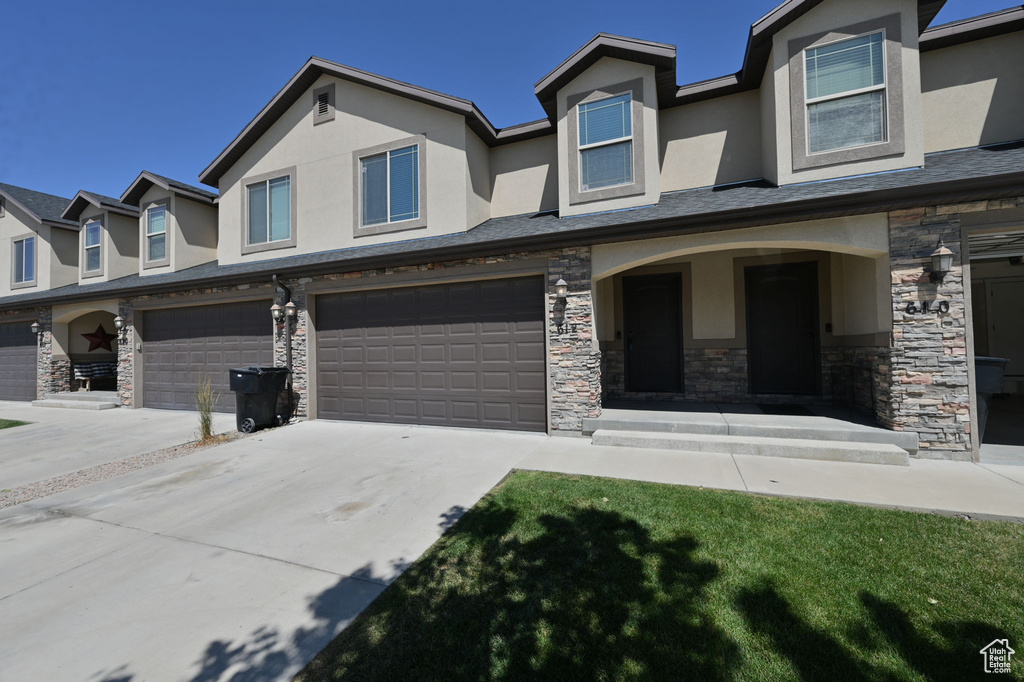 View of front facade featuring a front lawn and a garage