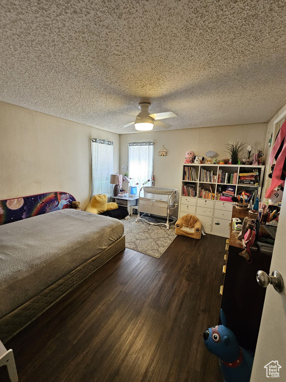 Bedroom with ceiling fan, a textured ceiling, and hardwood / wood-style flooring