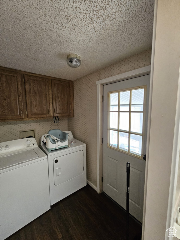 Washroom featuring hookup for a washing machine, dark hardwood / wood-style flooring, a textured ceiling, separate washer and dryer, and cabinets