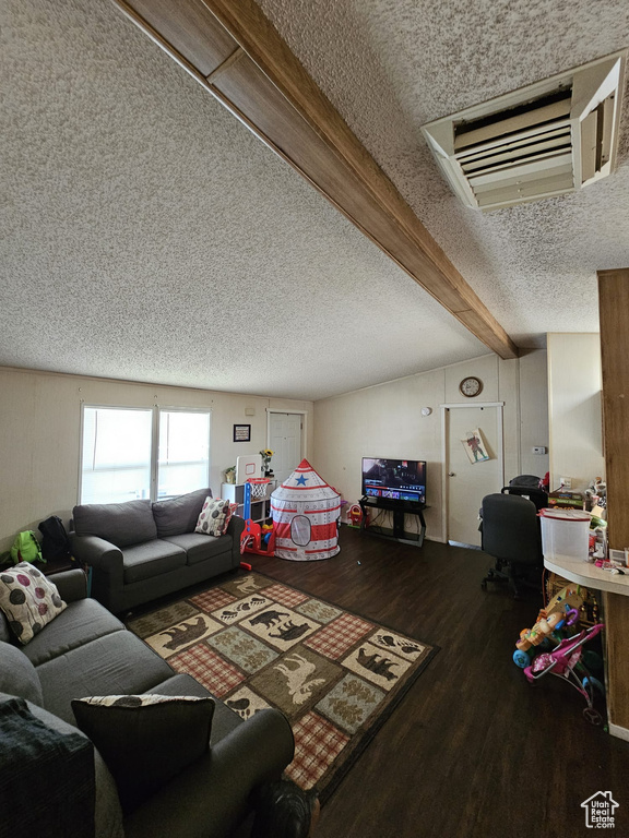 Living room with hardwood / wood-style flooring, vaulted ceiling with beams, and a textured ceiling