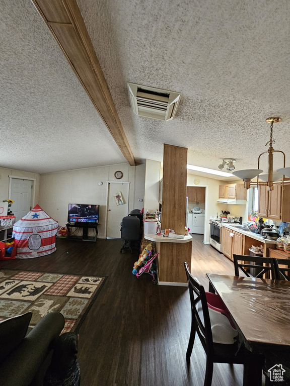 Dining area with beam ceiling, a textured ceiling, wood-type flooring, and washer / dryer