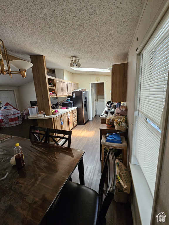 Dining area with a textured ceiling and light wood-type flooring