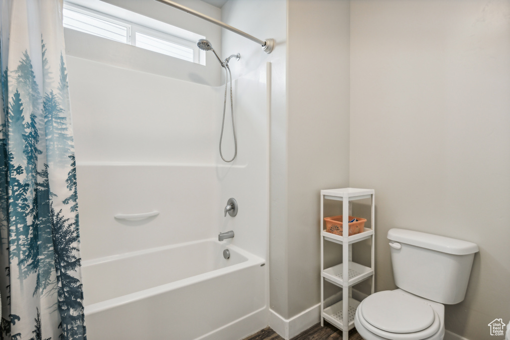 Bathroom with shower / bath combination with curtain and toilet