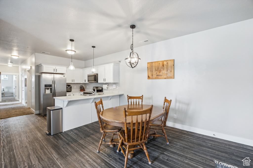 Carpeted dining space featuring a chandelier