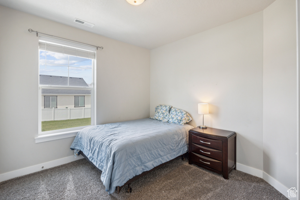 Bedroom featuring dark carpet